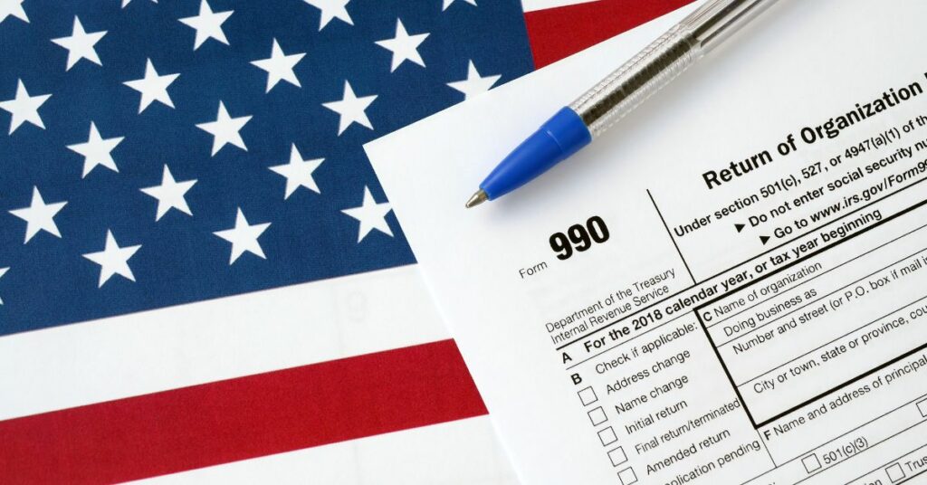 American flag with a IRS form 990 in the foreground