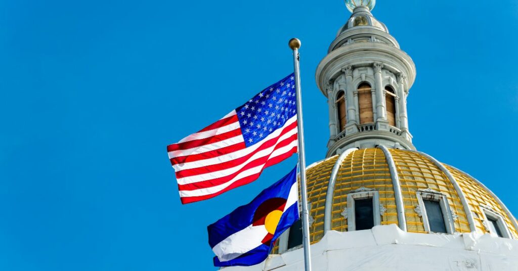 Colorado capitol building with an American flag and a Colorado state flag